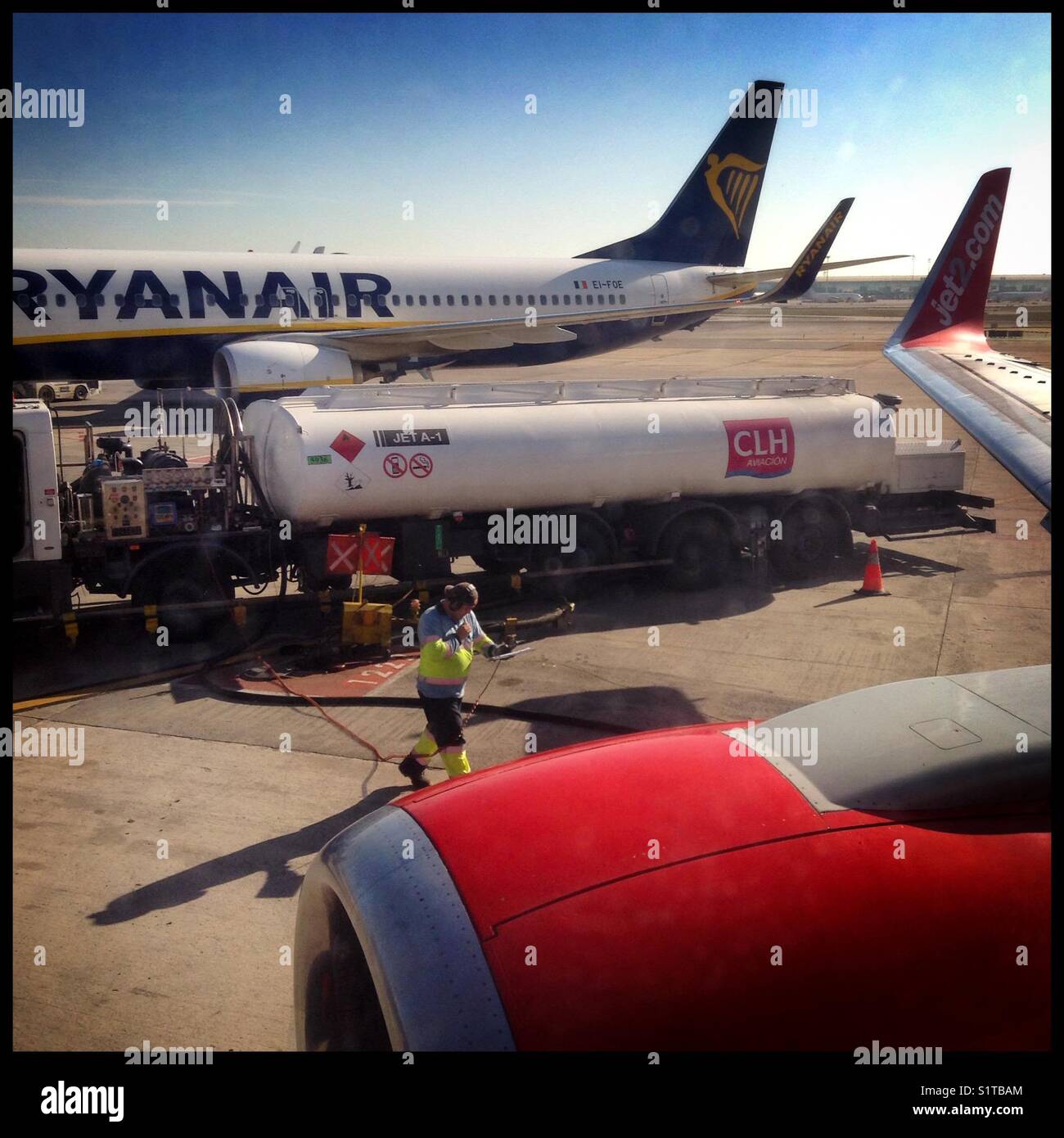 Mit Blick auf einen Ryanair Flug während ein Jet2 Boeing 737-800 Flugzeuge in Barcelona [BCN] El Prat Flughafen betankt wird, Barcelona, Spanien. Stockfoto