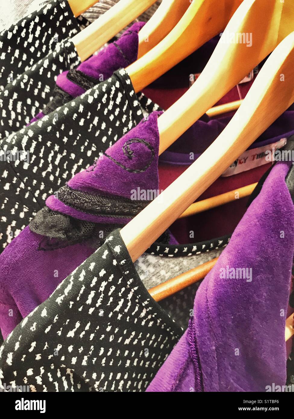 Kleider auf Kleiderbügeln im Einzelhandel Fashion Outlet - Smartphone-aufgenommenes Stockfoto