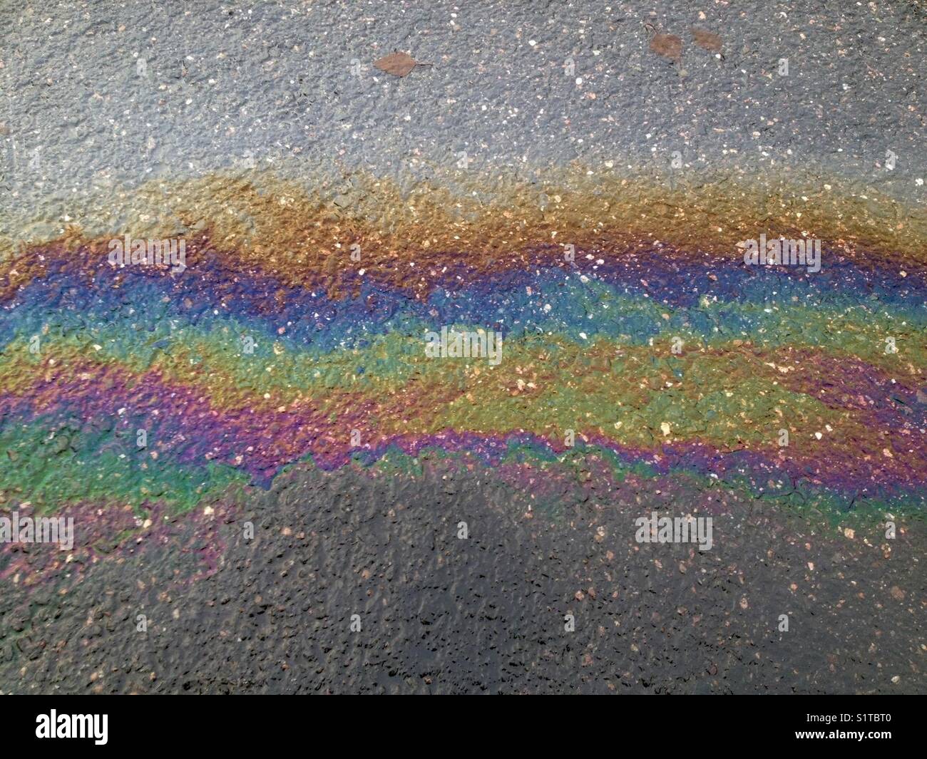 Ölpest auf Asphalt - Smartphone-aufgenommenes Stockfoto