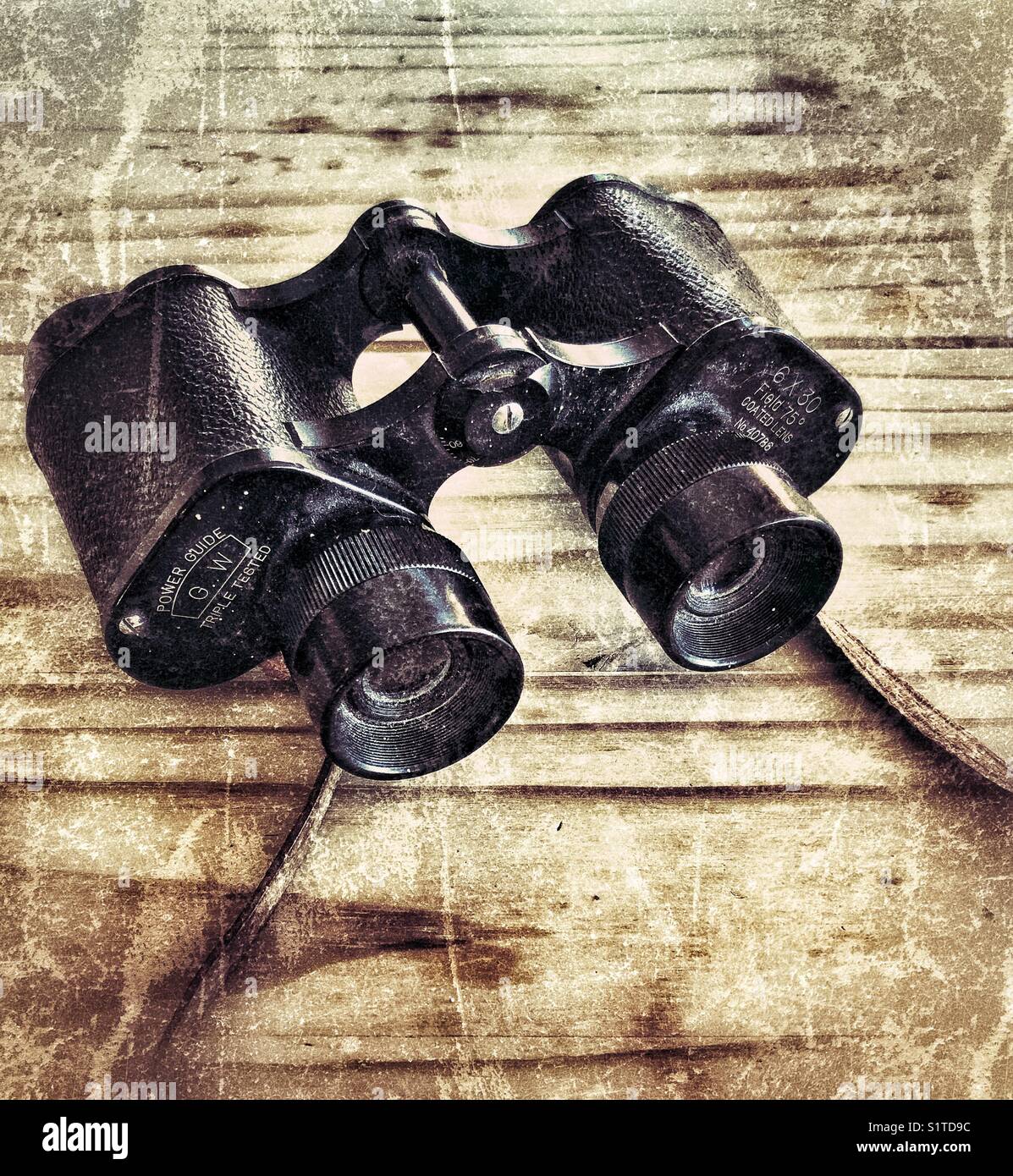 Altes Vintage-Fernglas mit Lederarmband auf einem Holztisch - Smartphone-aufgenommenes Stockfoto