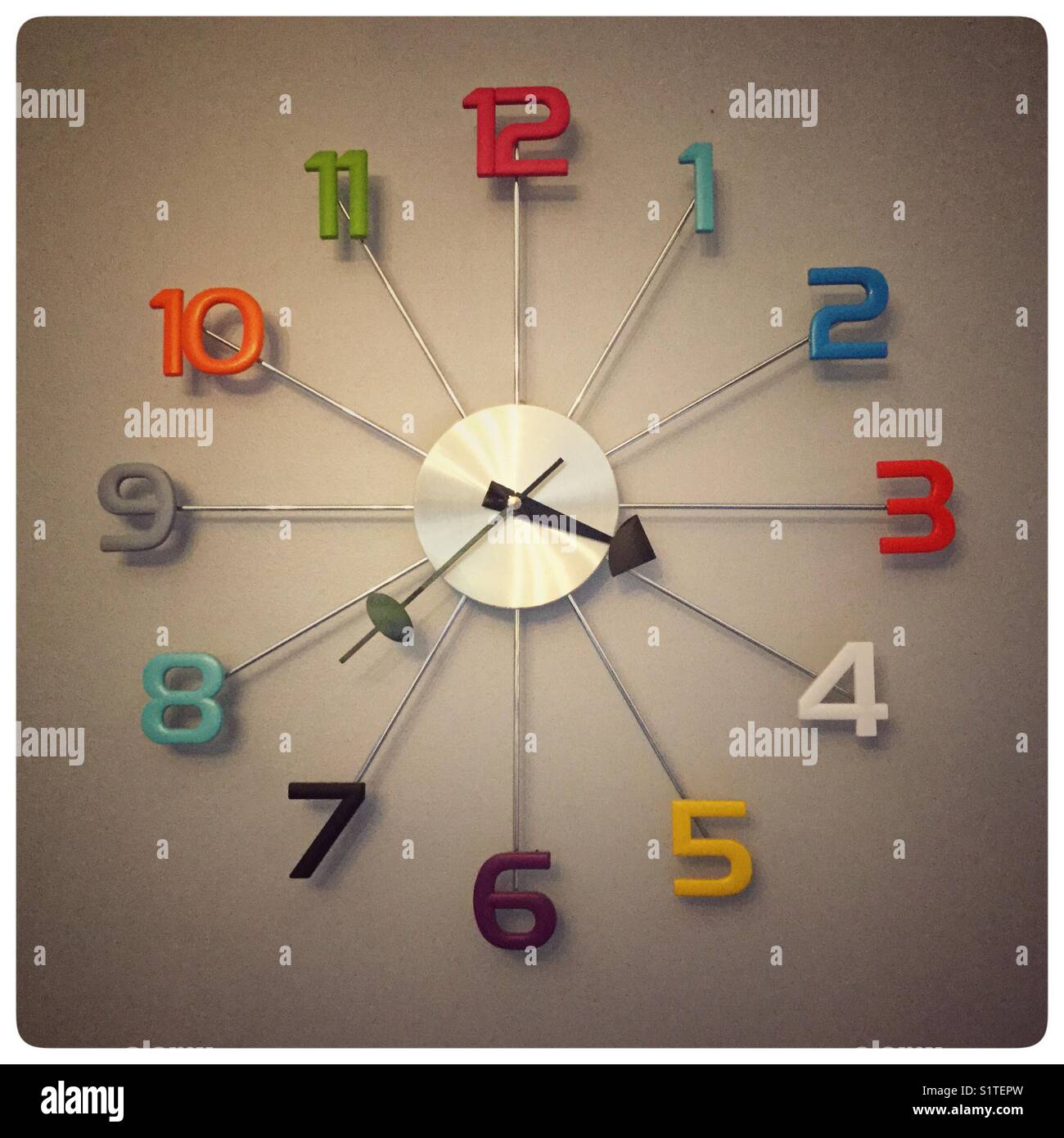 Moderne Uhr auf einer Tan farbigen Wand. Stockfoto