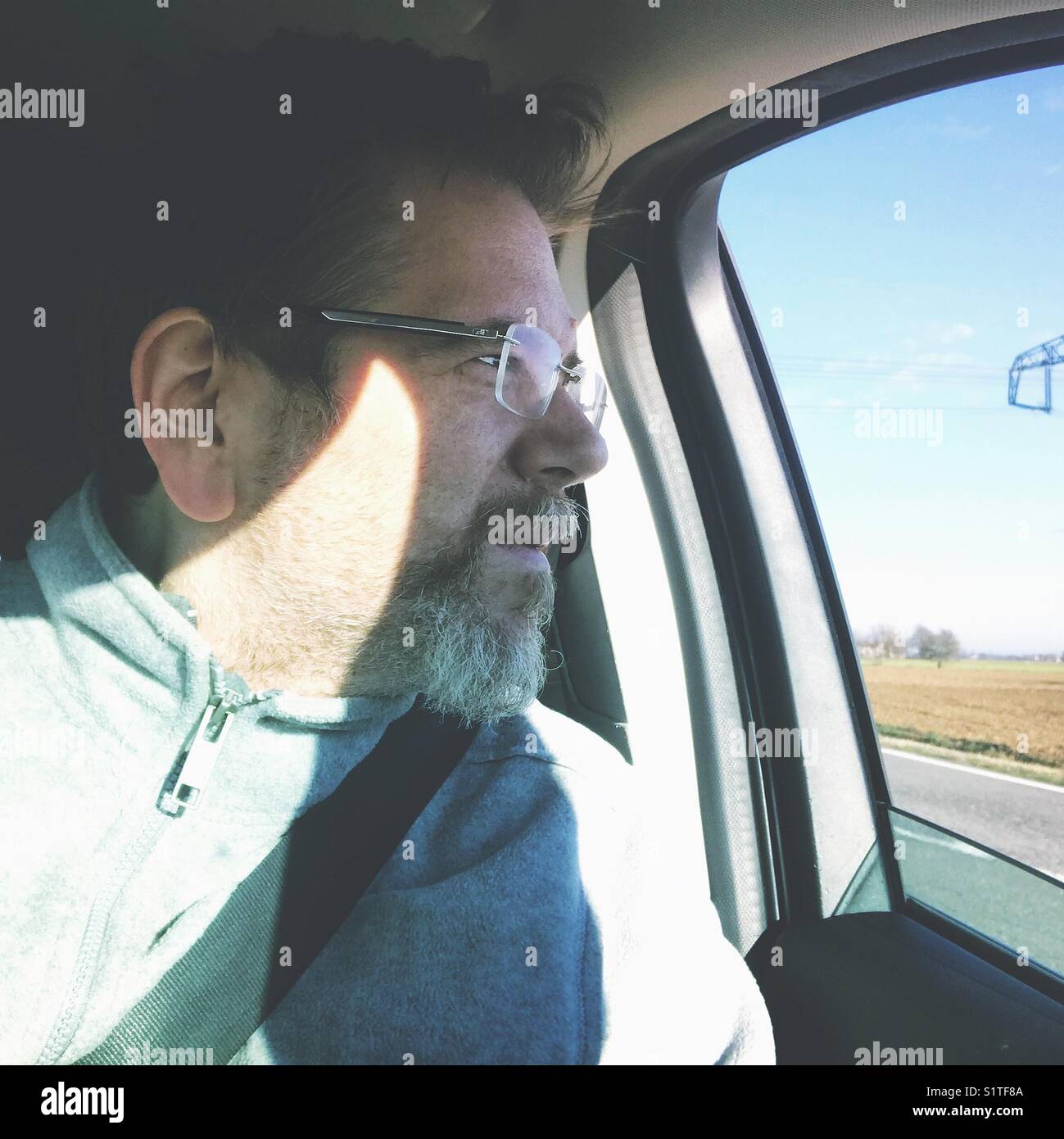Männer in einem Auto, die durch das Fenster schauen - Smartphone-aufgenommenes Stockfoto