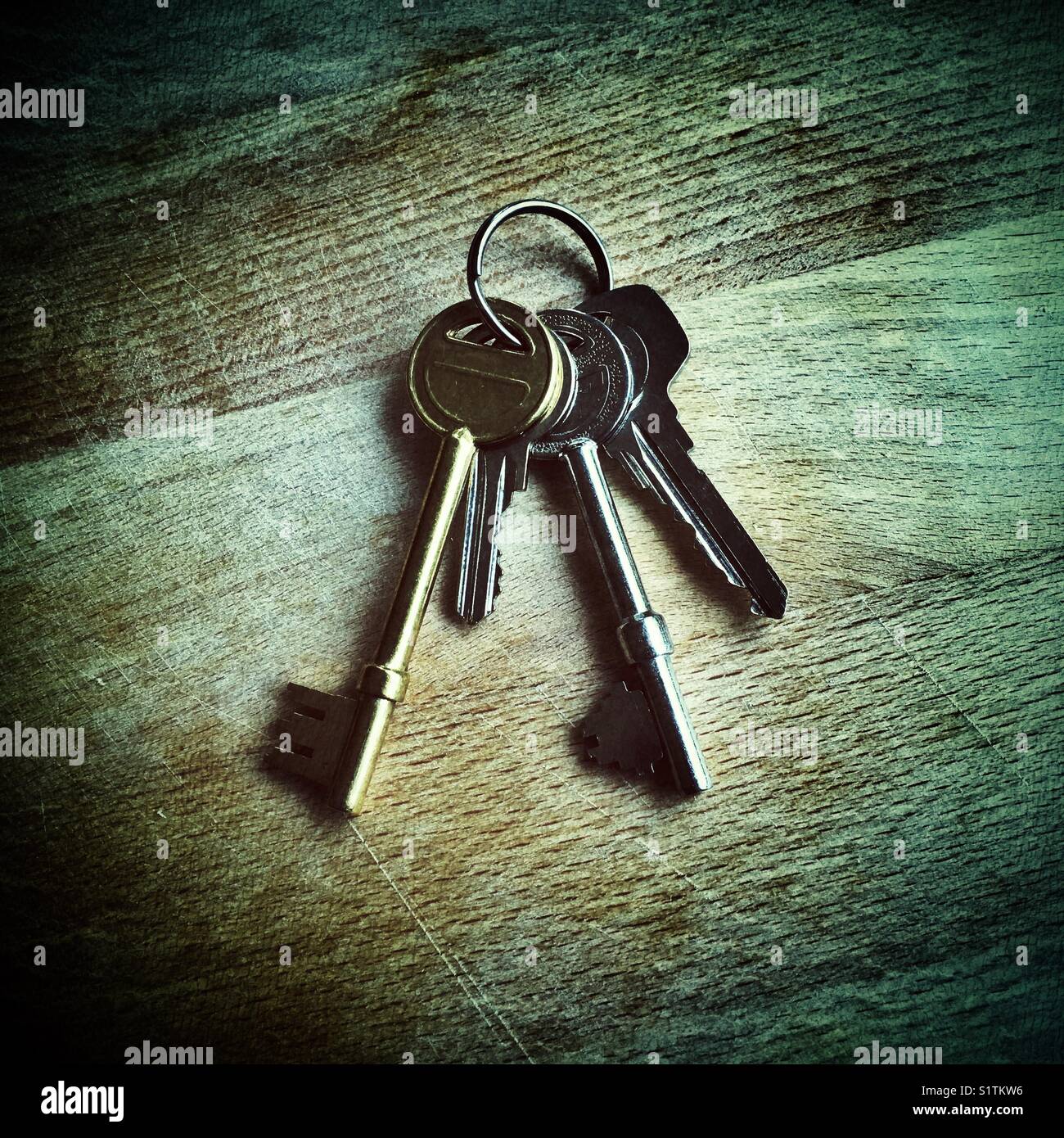 Ein kleiner Haufen verschiedener Haus- oder Büroschlüssel auf Holztisch, UK Stockfoto