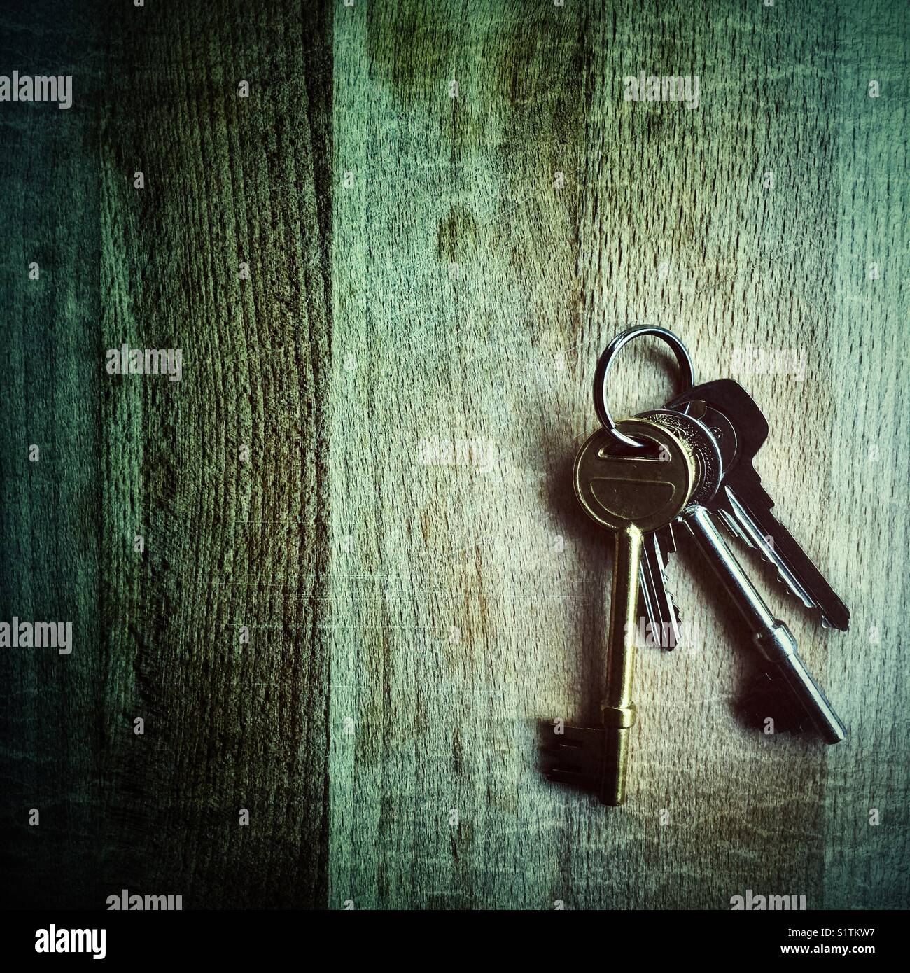 Ein kleiner Haufen verschiedener Haus- oder Büroschlüssel auf Holztisch, UK Stockfoto