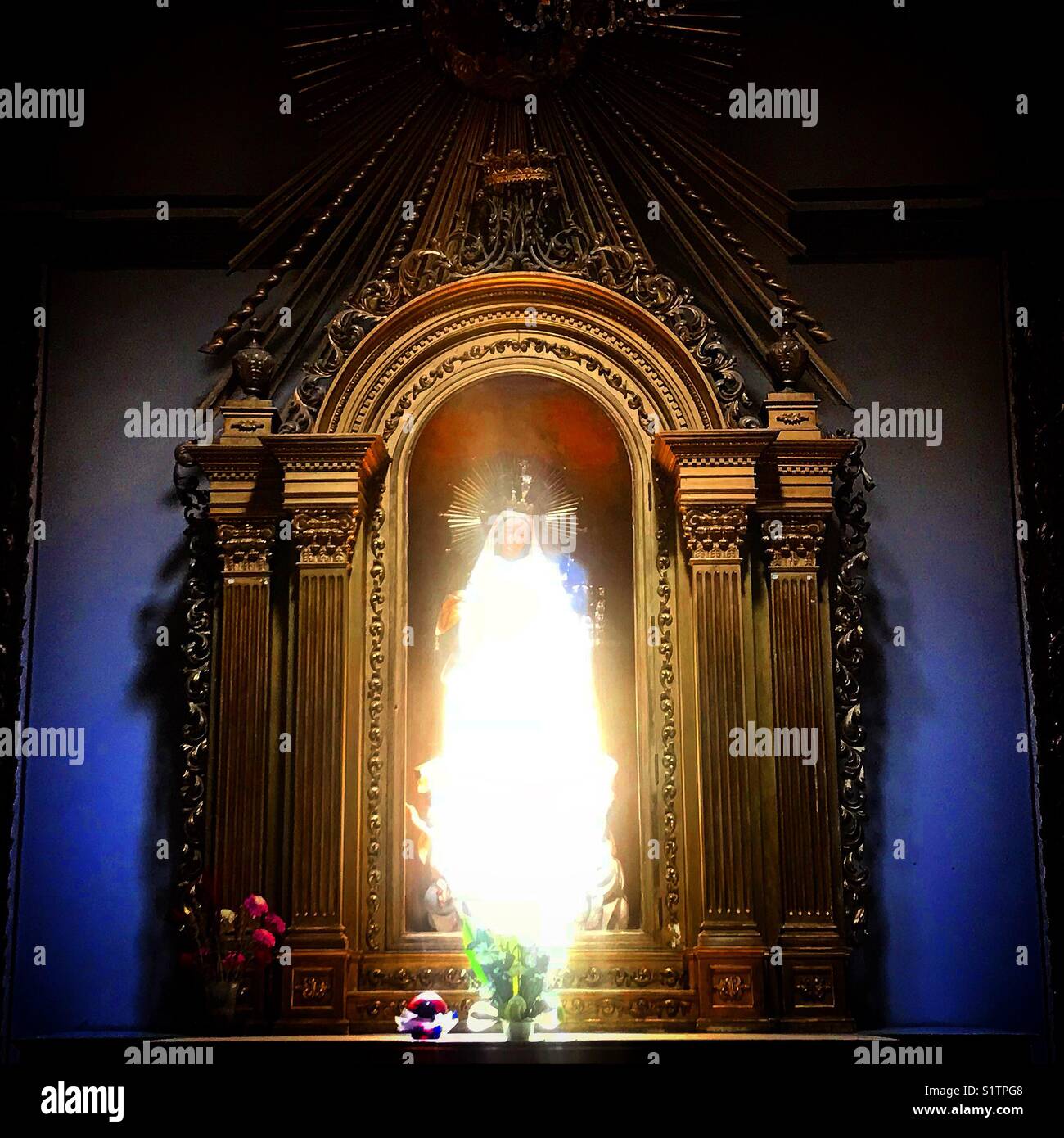 Ein Strahl aus Sonnenlicht leuchtet ein Bild der Jungfrau Maria in der Kathedrale von Oaxaca, Mexiko - Smartphone-aufgenommenes Stockfoto