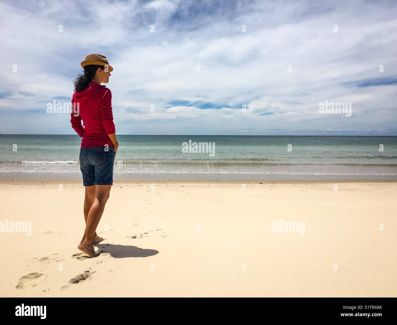 Attraktive junge Frau in rosa Shirt und Shorts, wachen am Strand Stockfoto