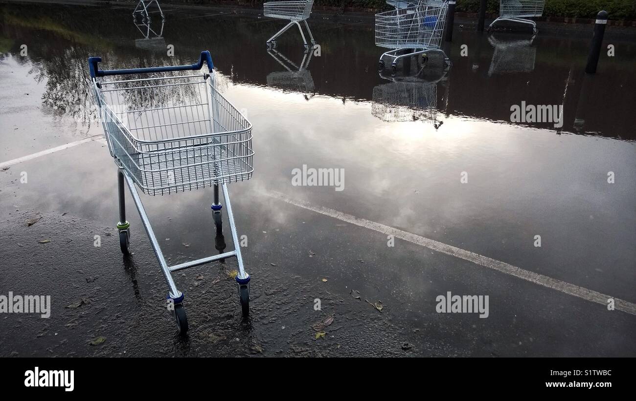 Verworfen Supermarkt Karren in einem überschwemmten Parkplatz. Stockfoto