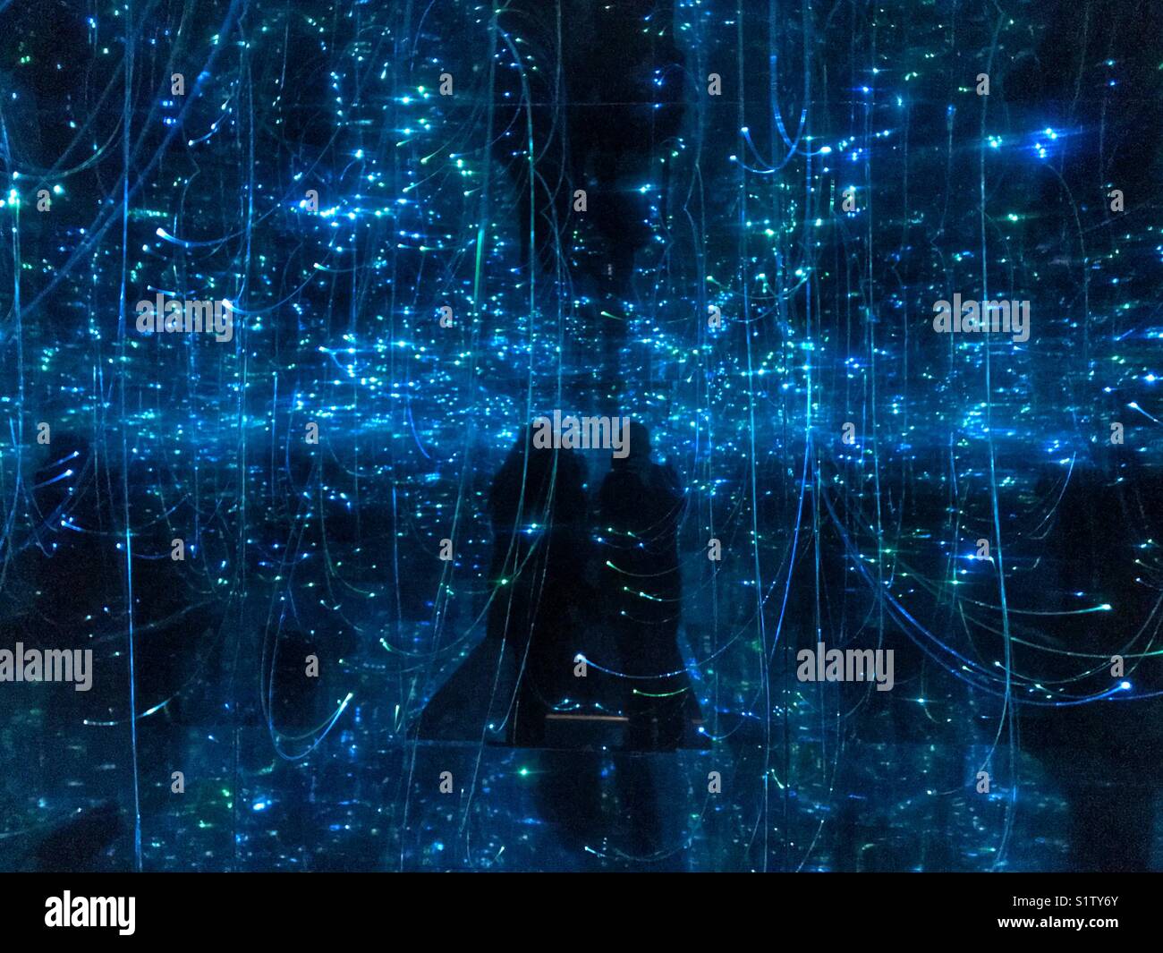 Zwei erwachsene Schatten in Infinity Space Cube Stockfoto