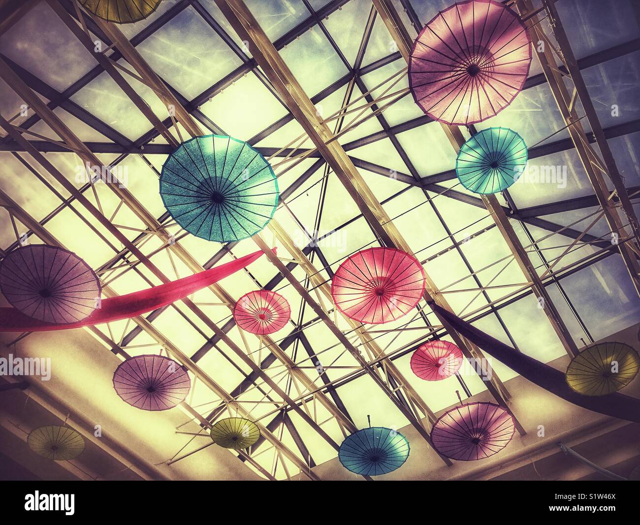 Bunte Papier Schirme hängen von Oberlicht Stockfoto