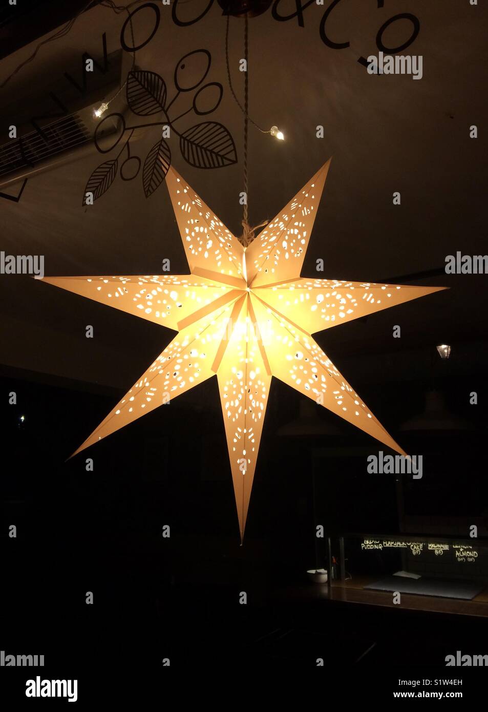 Weihnachten star Dekoration aufhängen im Fenster eines Cotswold Cafe, Großbritannien Stockfoto