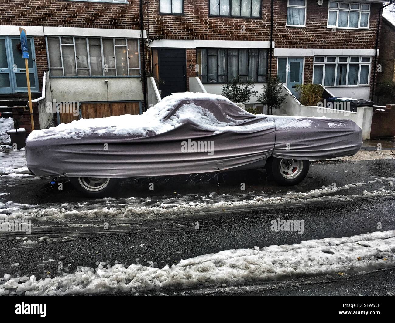 Ein Auto mit Schnee bedeckt - Smartphone-aufgenommenes Stockfoto