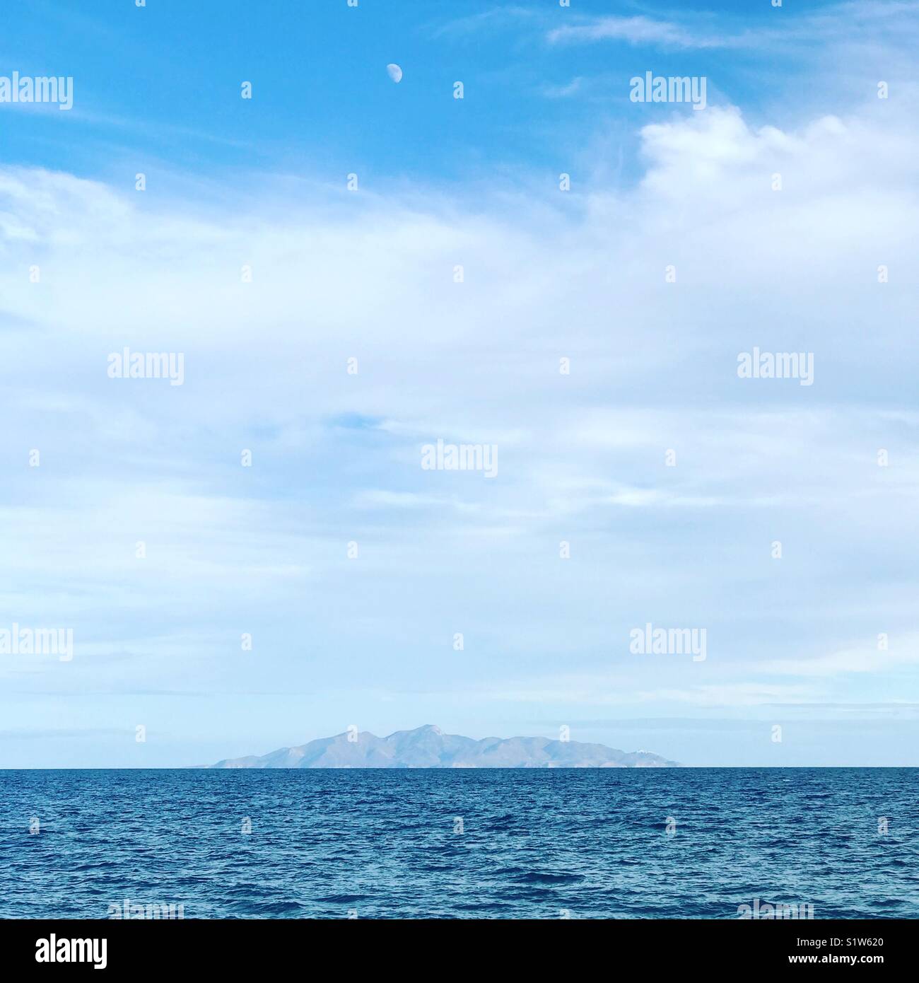 Ein Blick auf die Ägäis in den Vordergrund mit dem Klisidi Insel im Hintergrund und der Mond auf der Oberseite - Smartphone-aufgenommenes Stockfoto