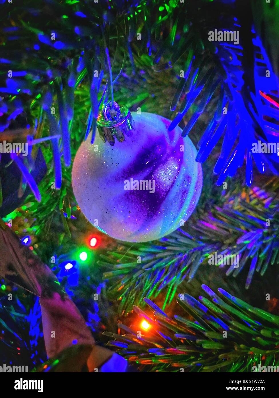 Weihnachtskugel mit den Lichtern erzeugen bunte Formen auf der Oberfläche - Smartphone-aufgenommenes Stockfoto