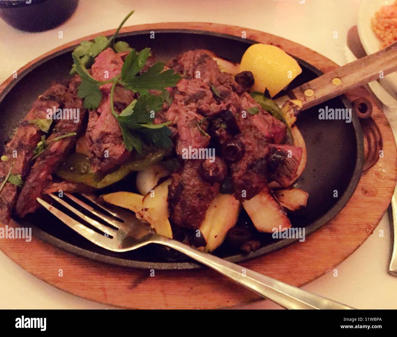 Steak fajitas auf sizzling platter an gehobene mexikanische Restaurant, New York City, USA - Smartphone-aufgenommenes Stockfoto