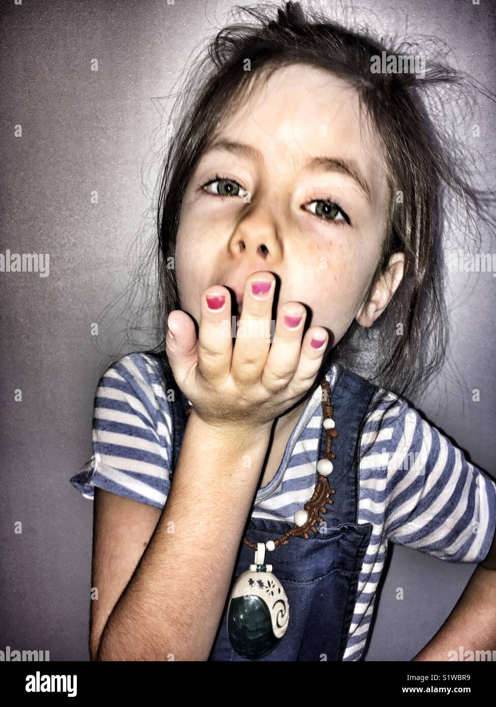 Mädchen bläst einen Kuss - Smartphone-aufgenommenes Stockfoto