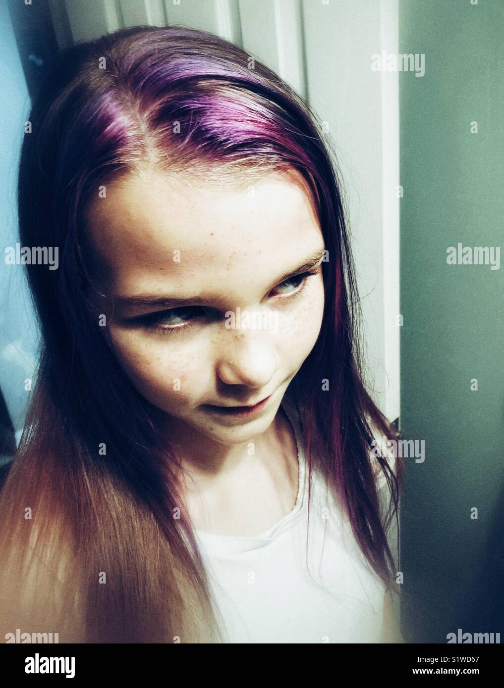 10-jähriges Mädchen auf der Suche nach Ihrem neuen lila Haar streifen Stockfoto