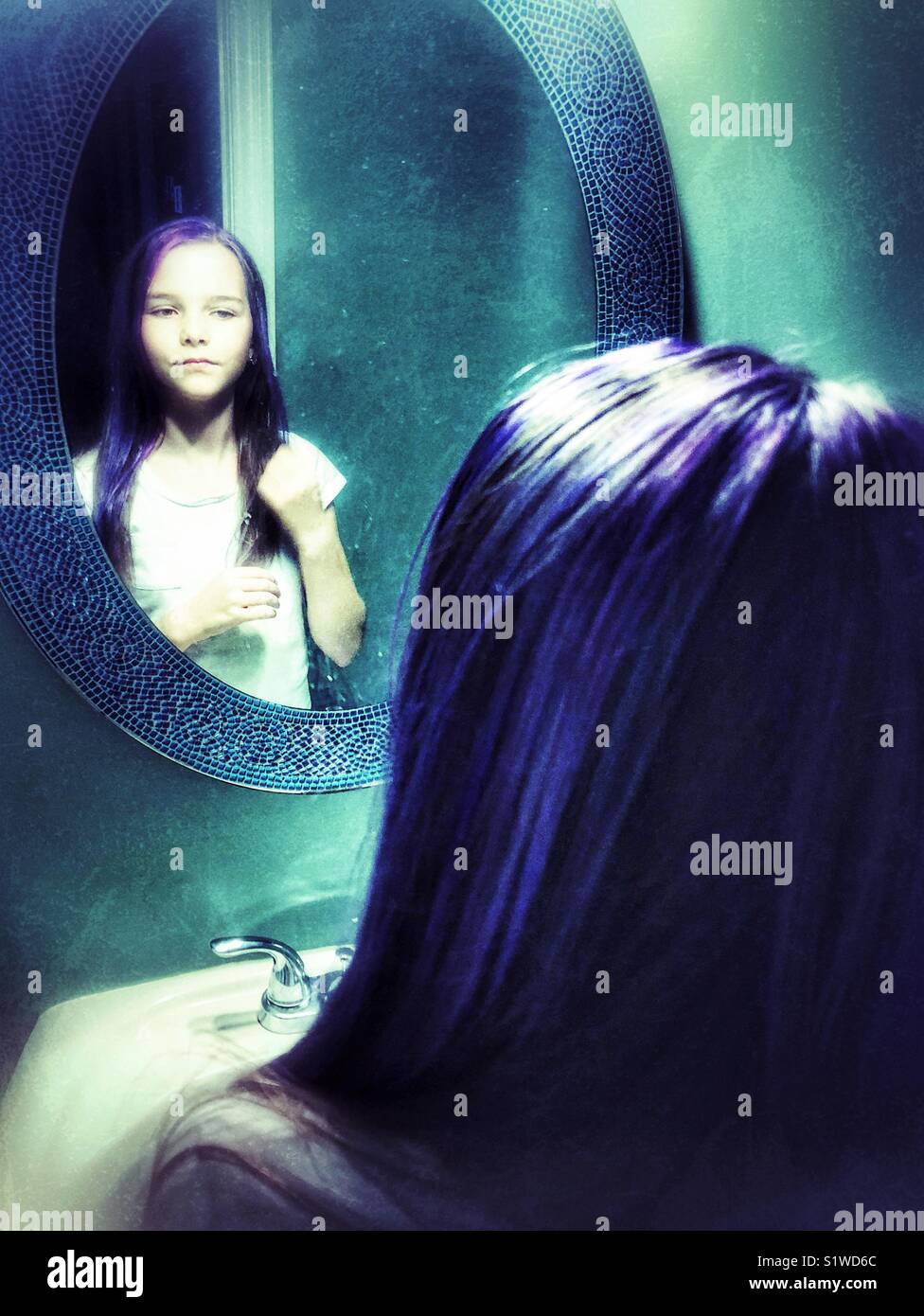 10 Jahre altes Mädchen an neu gemacht lila Haarfarbe in Bad spiegel Reflexion suchen Stockfoto
