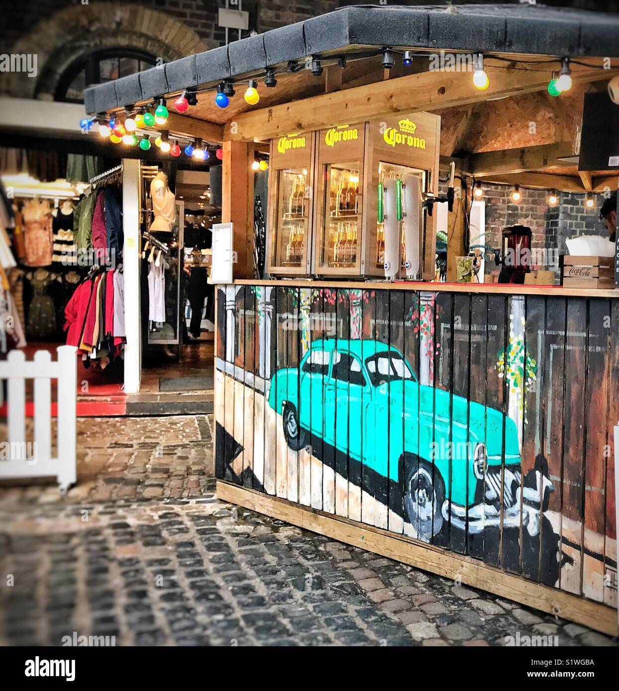 Wunderschön handbemalt bar vorne mit kubanischen Stil auto Motiv in Camden Lock Market, London mit Einzelhändlern im Hintergrund - Smartphone-aufgenommenes Stockfoto