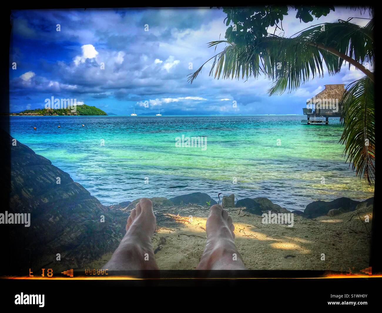 Am Strand Relaxen mit Blick auf das Wasser in Bora Bora, Französisch-Polynesien - Smartphone-aufgenommenes Stockfoto