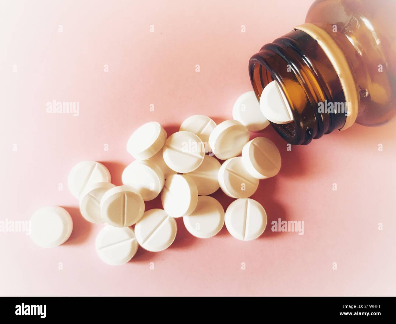 Gesundheitswesen und Medizin. Generische weiße Tabletten verschütten aus braunem Glas Pilleflasche - Smartphone-aufgenommenes Stockfoto