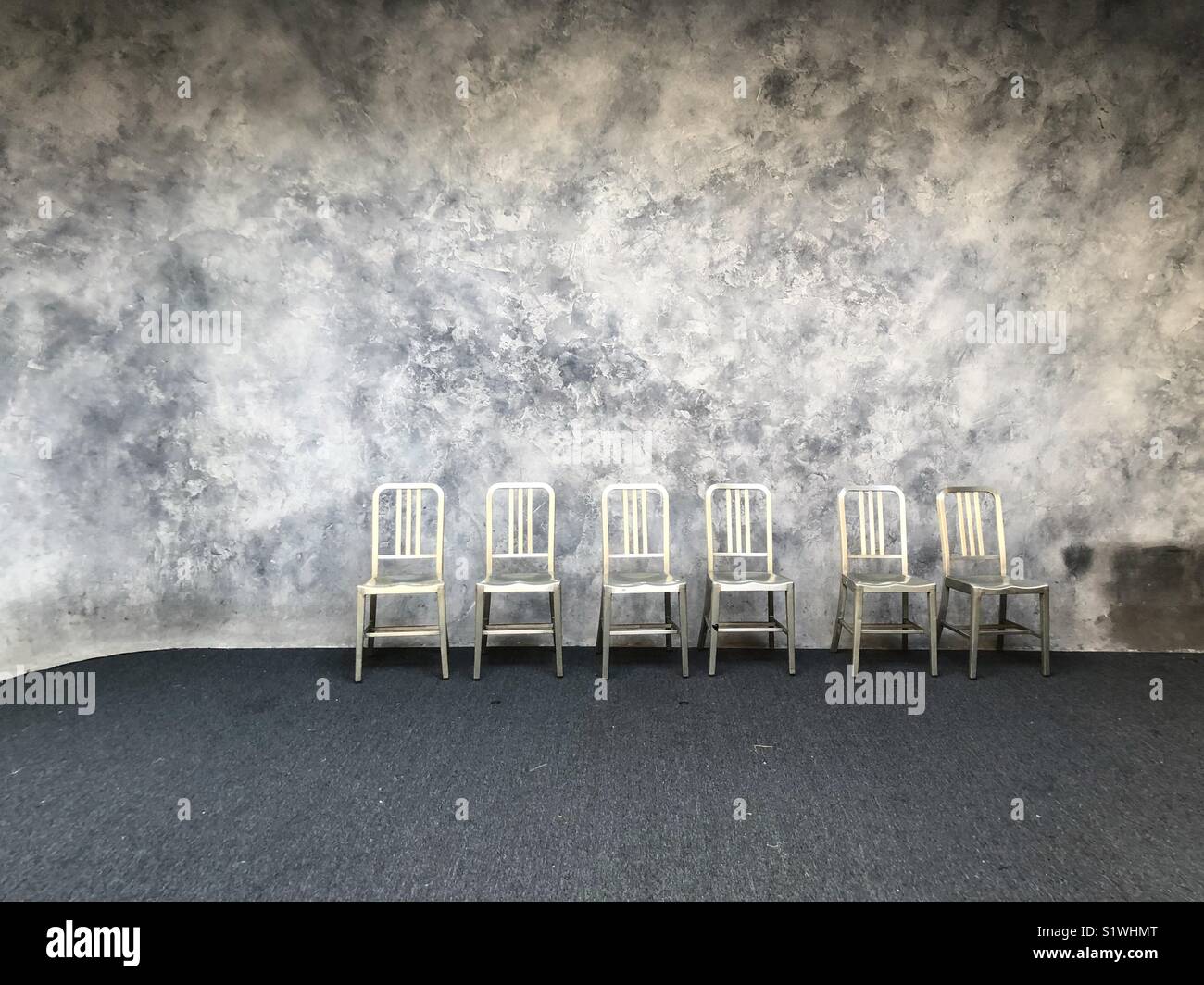 Stühle aufgereiht im leeren Zimmer Stockfoto