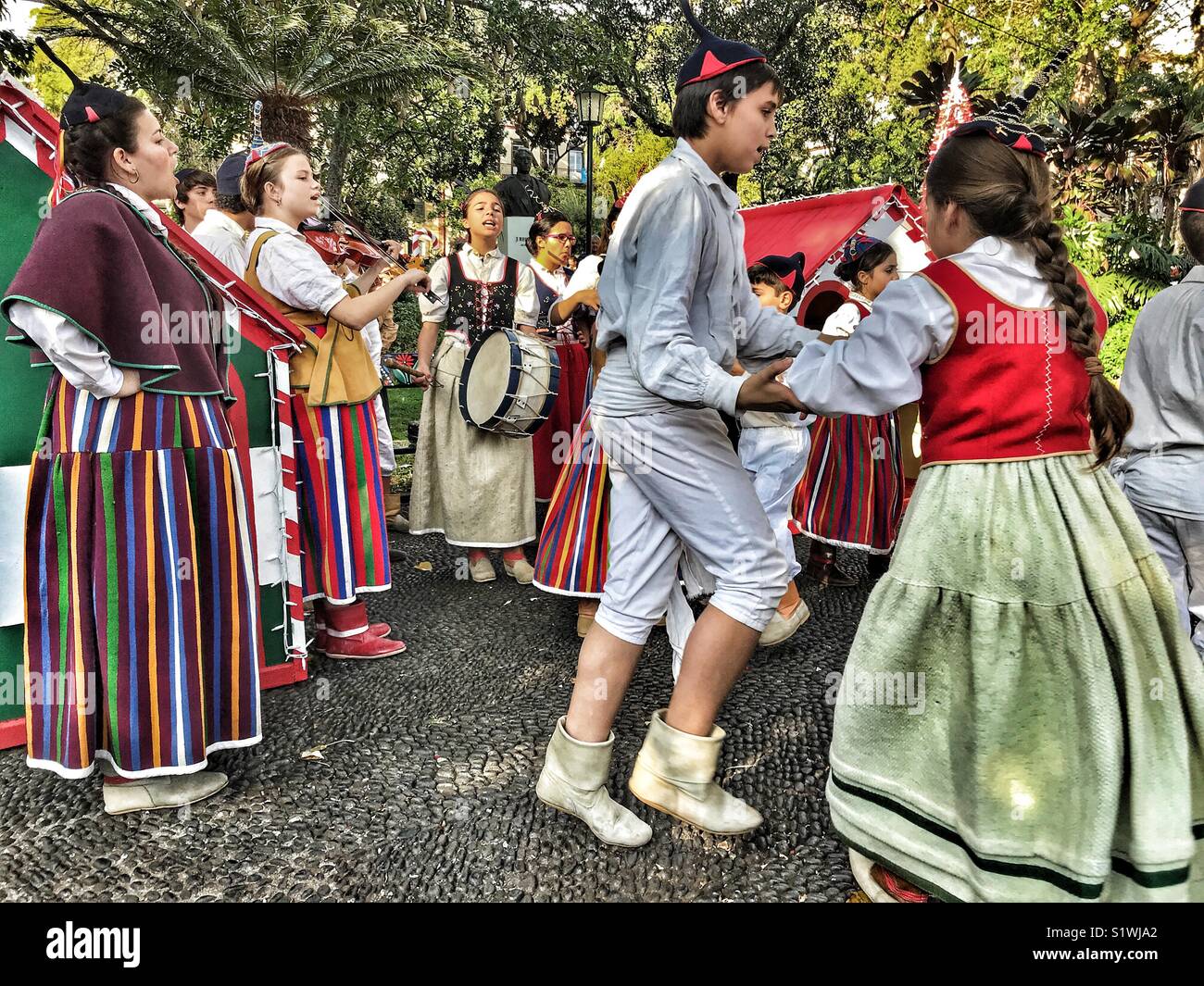 Gruppe von jungen Musikern und Volkstänzer in traditionellen Kostümen in den städtischen Gärten in der Vorweihnachtszeit, Funchal, Madeira, Portugal Stockfoto