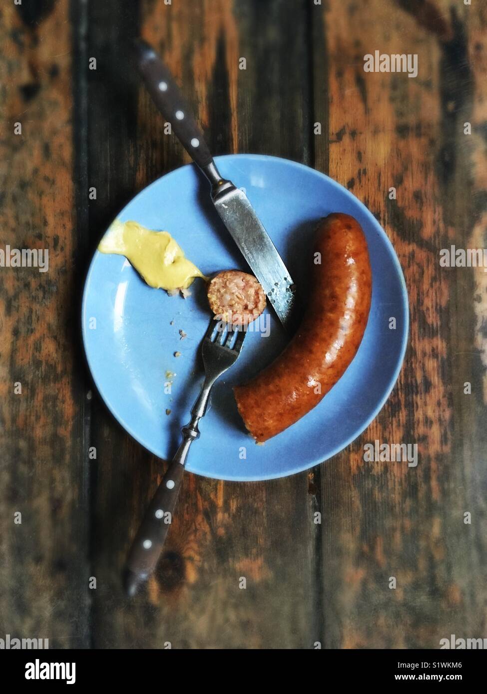 Die norddeutsche Spezialität wurst Pinkel von der Stadt Oldenburg auf einem blauen Schild mit Senf Stockfoto