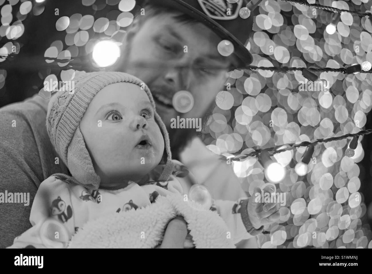 Ein Vati sein Baby die Weihnachtsbeleuchtung zum ersten Mal zu sehen. Stockfoto