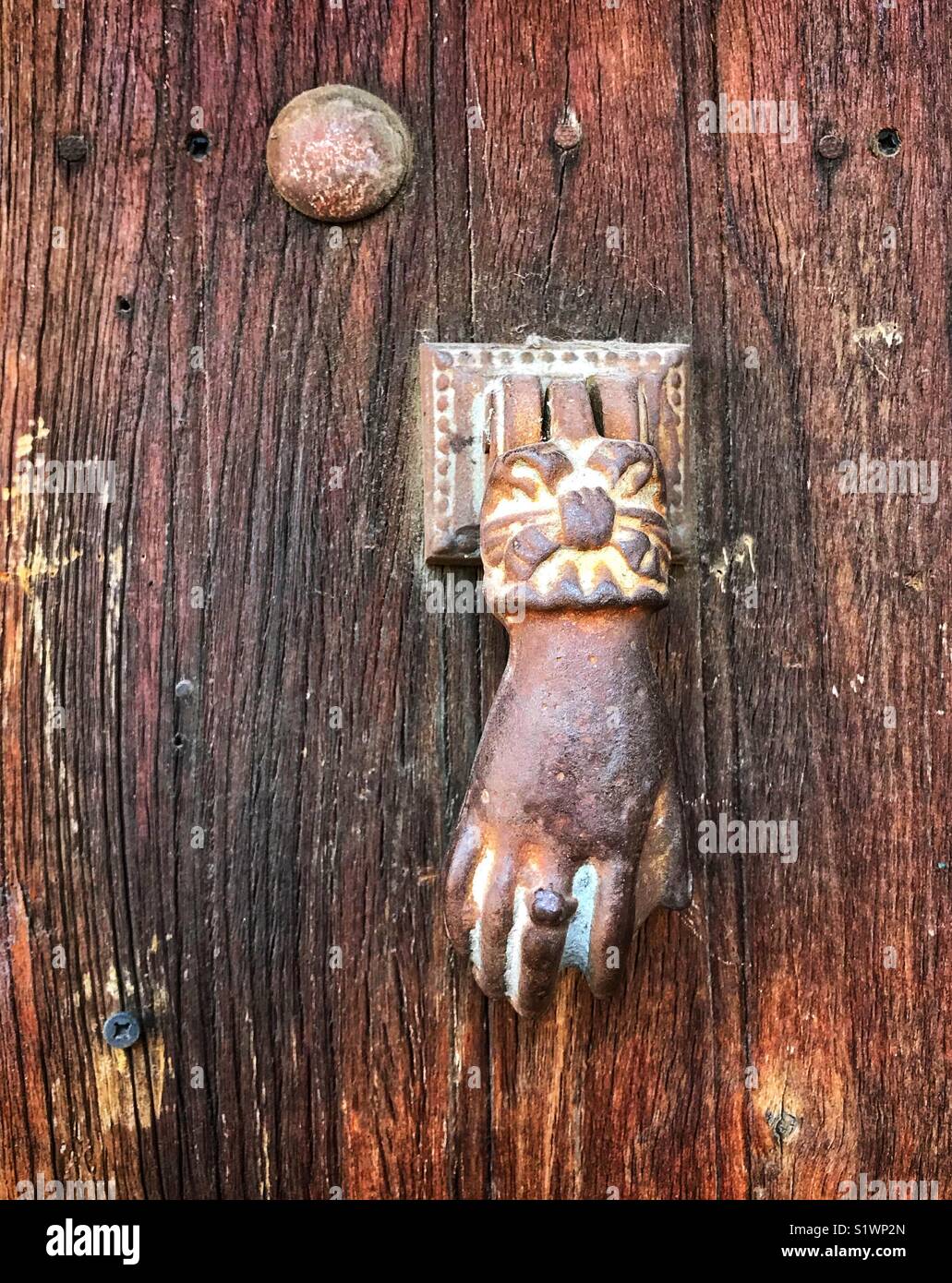 Eine weibliche Hand Türklopfer fügt einen skurrilen Touch zu dieser antiken hölzernen Tür in Ajijic, Mexiko. Stockfoto