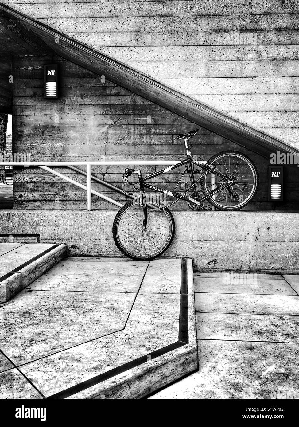Ein Fahrrad angekettet an ein Geländer am National Theatre, London. Stockfoto