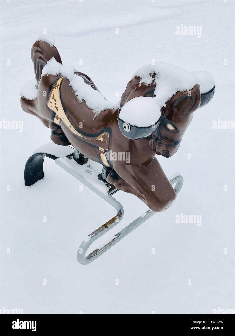 Spielplatz Feder Schaukelpferd im Schnee Stockfotografie - Alamy