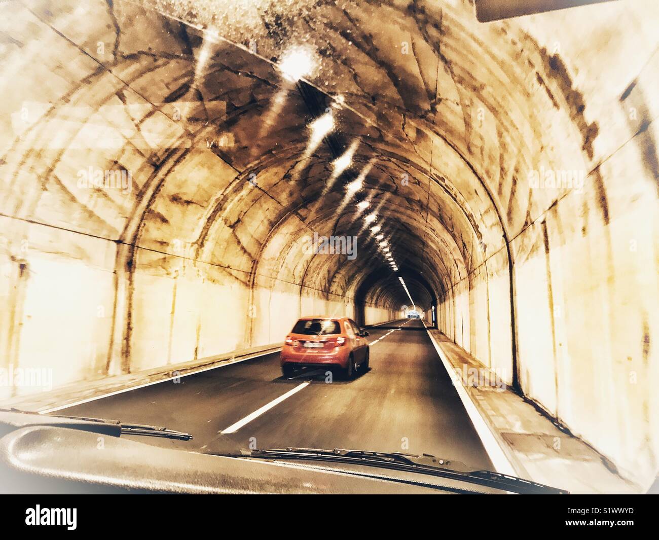Durch ein rotes Auto, während durch eine der vielen Tunnel auf der Insel Madeira, Portugal fahren überholt - Smartphone-aufgenommenes Stockfoto