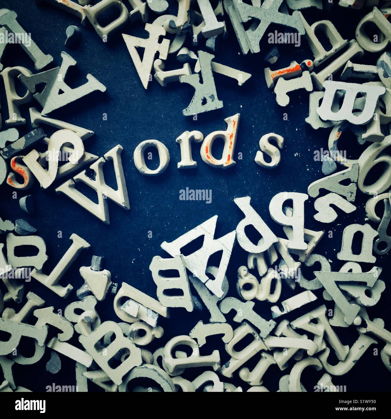 Wort Wörter in kleinen Metall serif Briefe durch Stapel von Briefen umgeben geschrieben Stockfoto