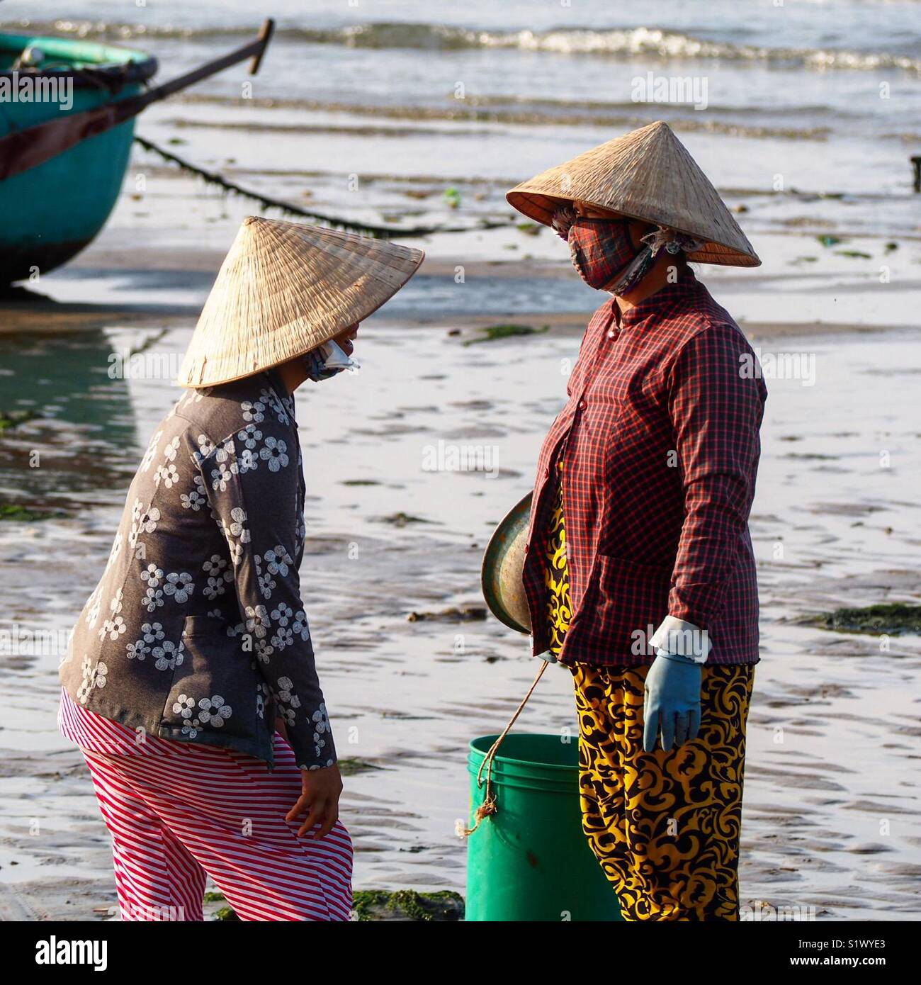 Ehefrauen Der vietnamesische Fischer auf ein Mann dort zu holen zurück nimmt. Stockfoto
