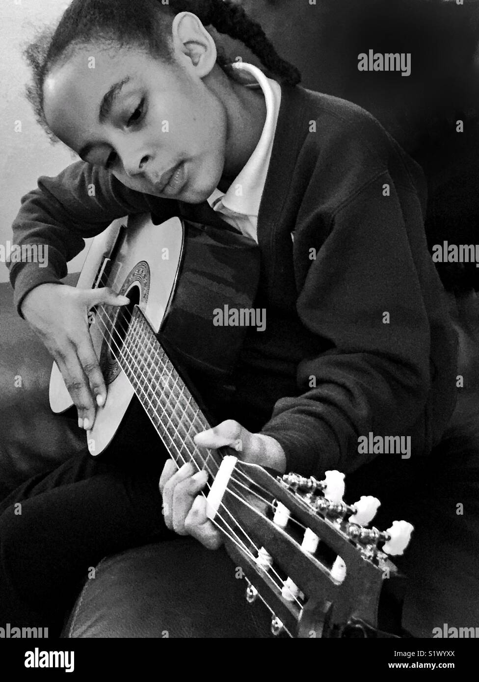 Ein junges Mädchen Spielen einer Gitarre. Stockfoto