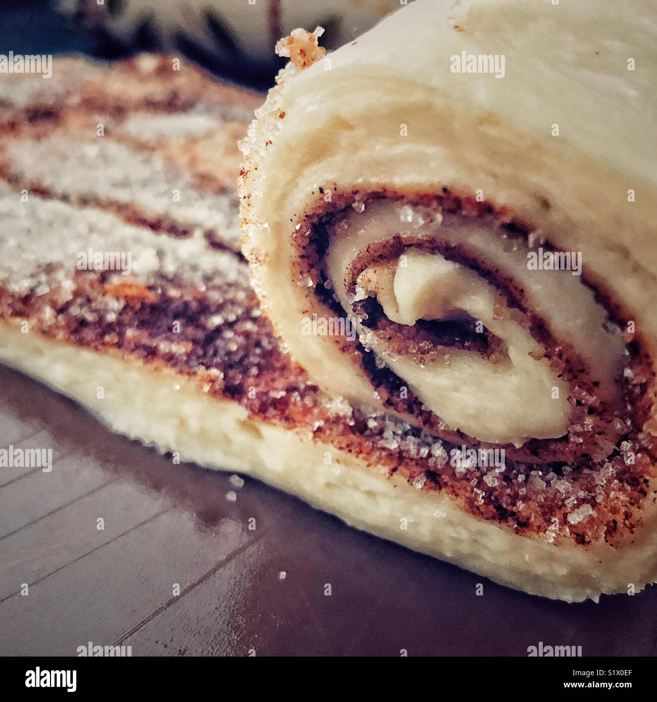 Rohen Teig mit Zimt und Zucker gerollt werden, Cinnamon Roll Brötchen zu machen Stockfoto