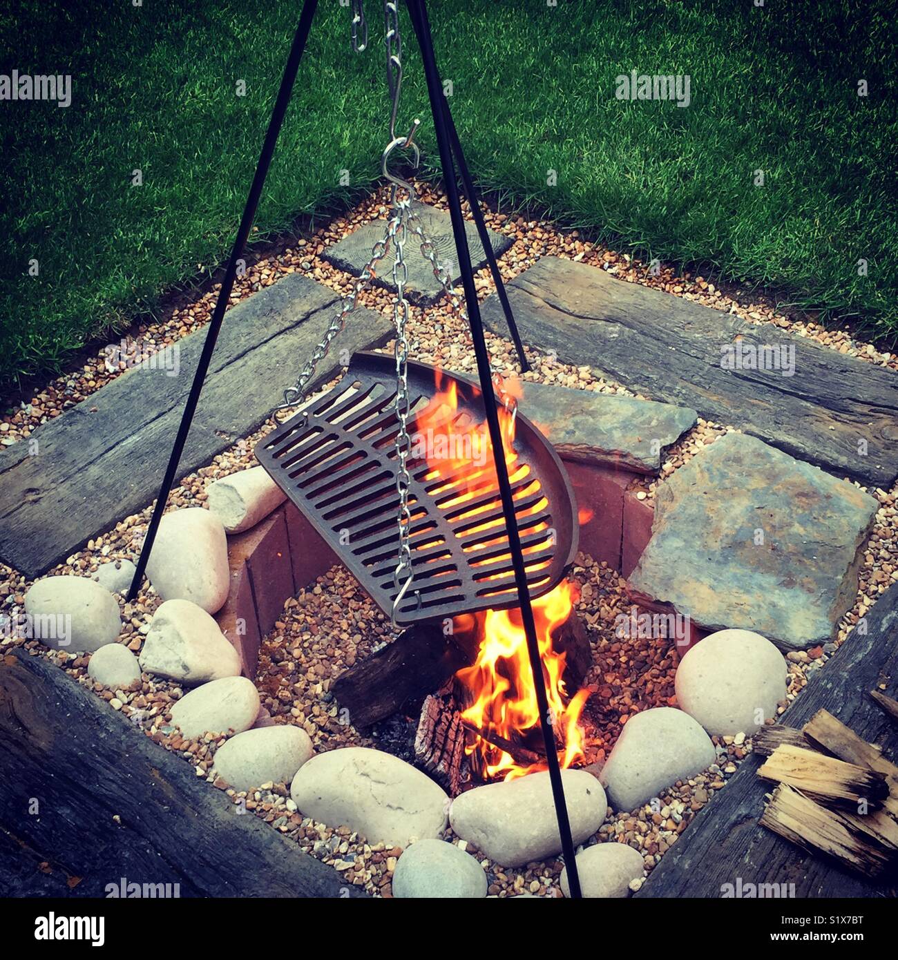 Eine Feuerstelle mit Feuer in einem Garten in Großbritannien - Smartphone-aufgenommenes Stockfoto