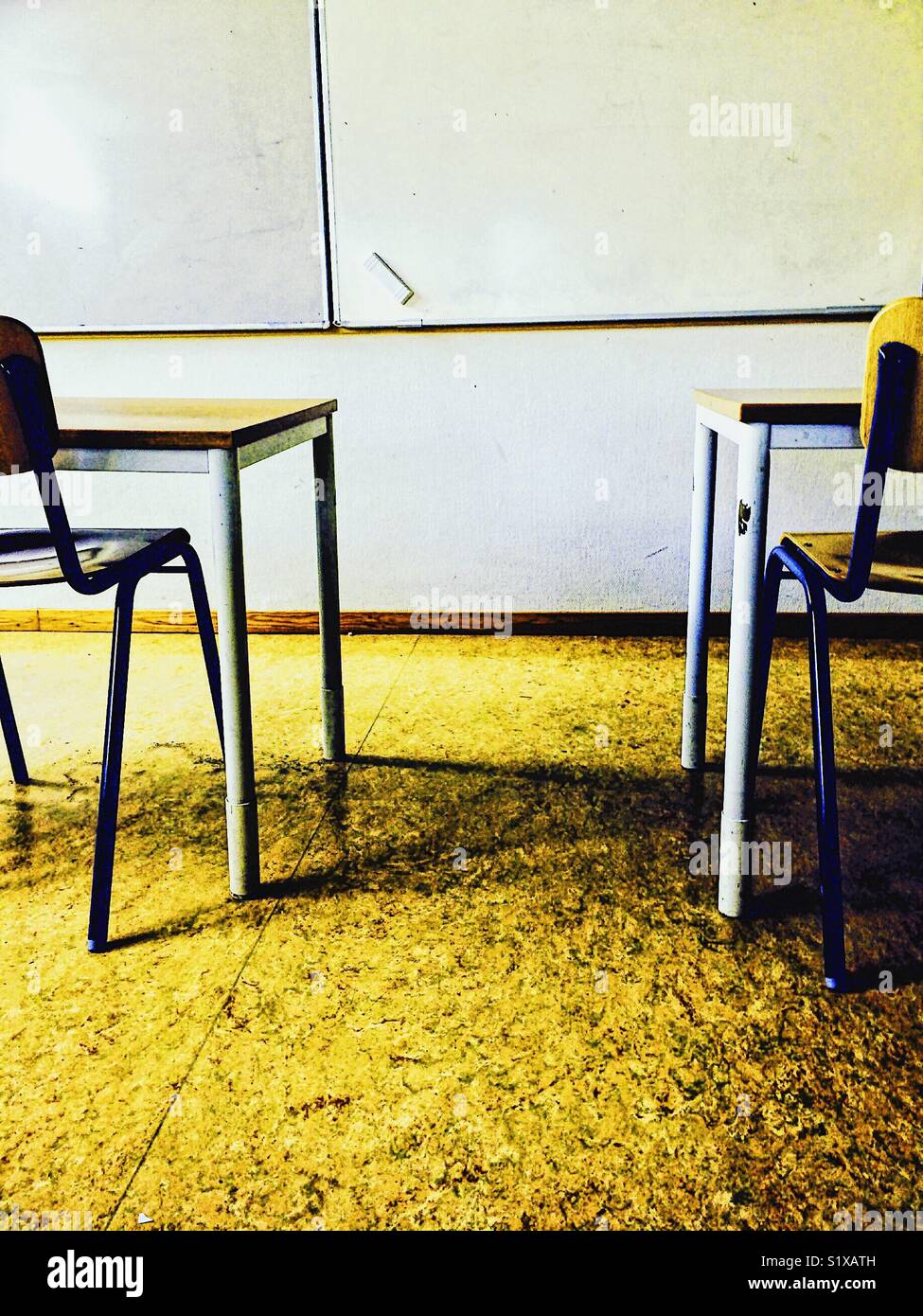Leere Klassenzimmer mit Whiteboard, Radierer, Tischen und Stühlen Stockfoto
