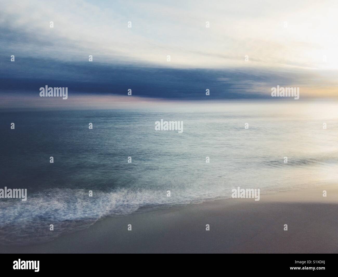 Lange Exposition der Wellen am Strand in Florida plätschern an der Küste des Golfs von Mexiko. - Smartphone-aufgenommenes Stockfoto