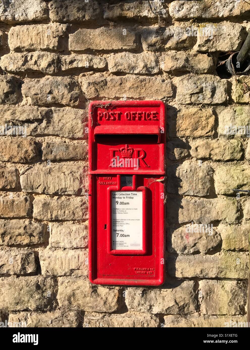 Post Box in einer Steinmauer in einem englischen Dorf Stockfoto