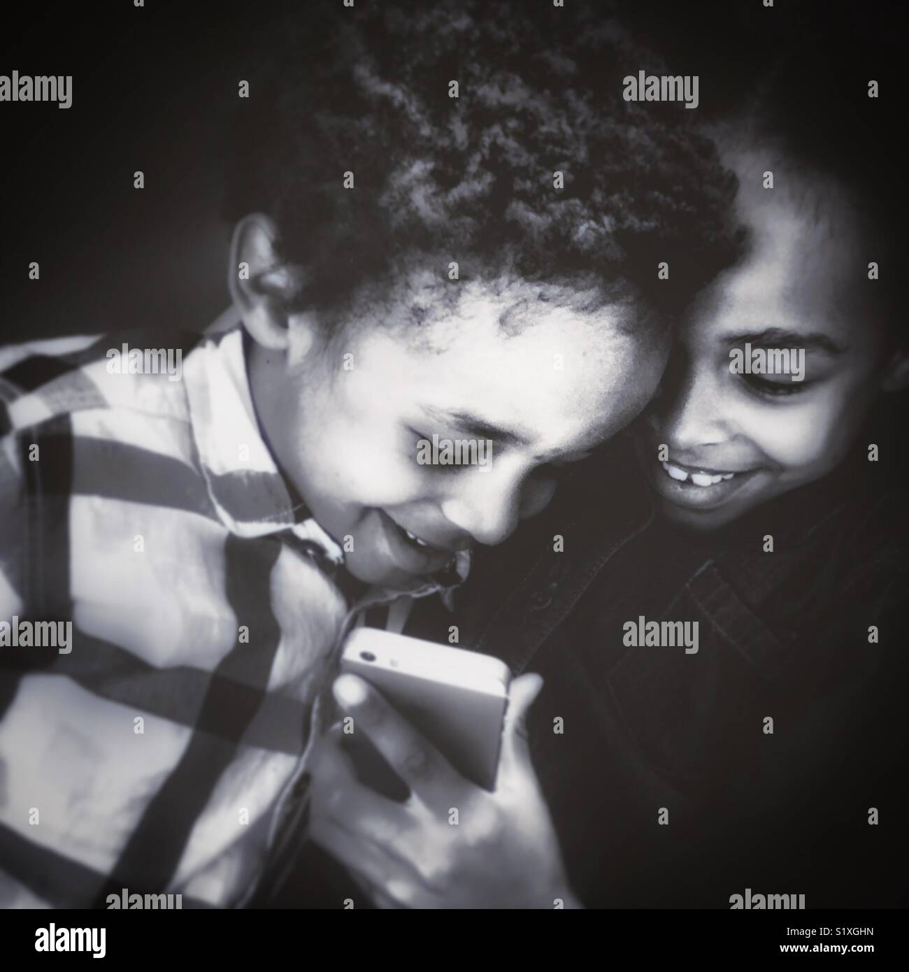 Kinder spielen mit einem Mobiltelefon. - Smartphone-aufgenommenes Stockfoto