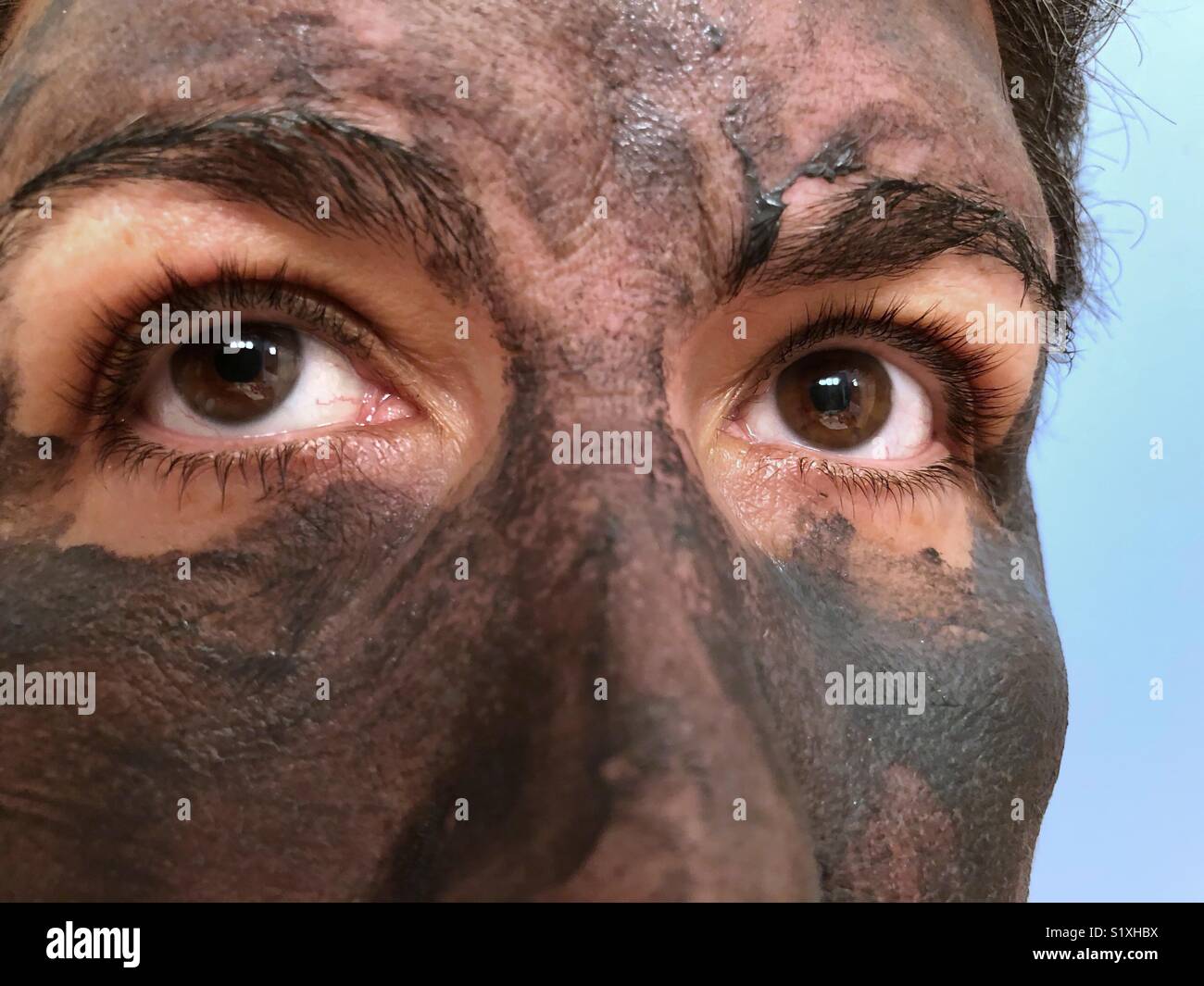 Eine extreme Nahaufnahme von Augen der Frau; die Frau trägt ein Schlamm Maske Stockfoto