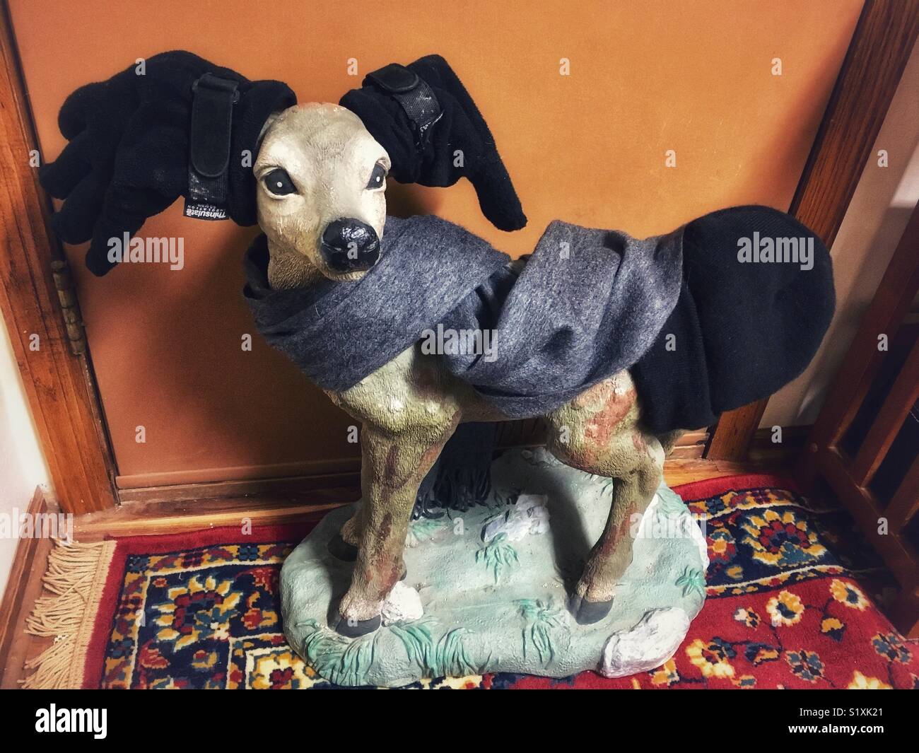 Deer lawn Ornament mit Schal, Handschuhe und Hut - Smartphone-aufgenommenes Stockfoto