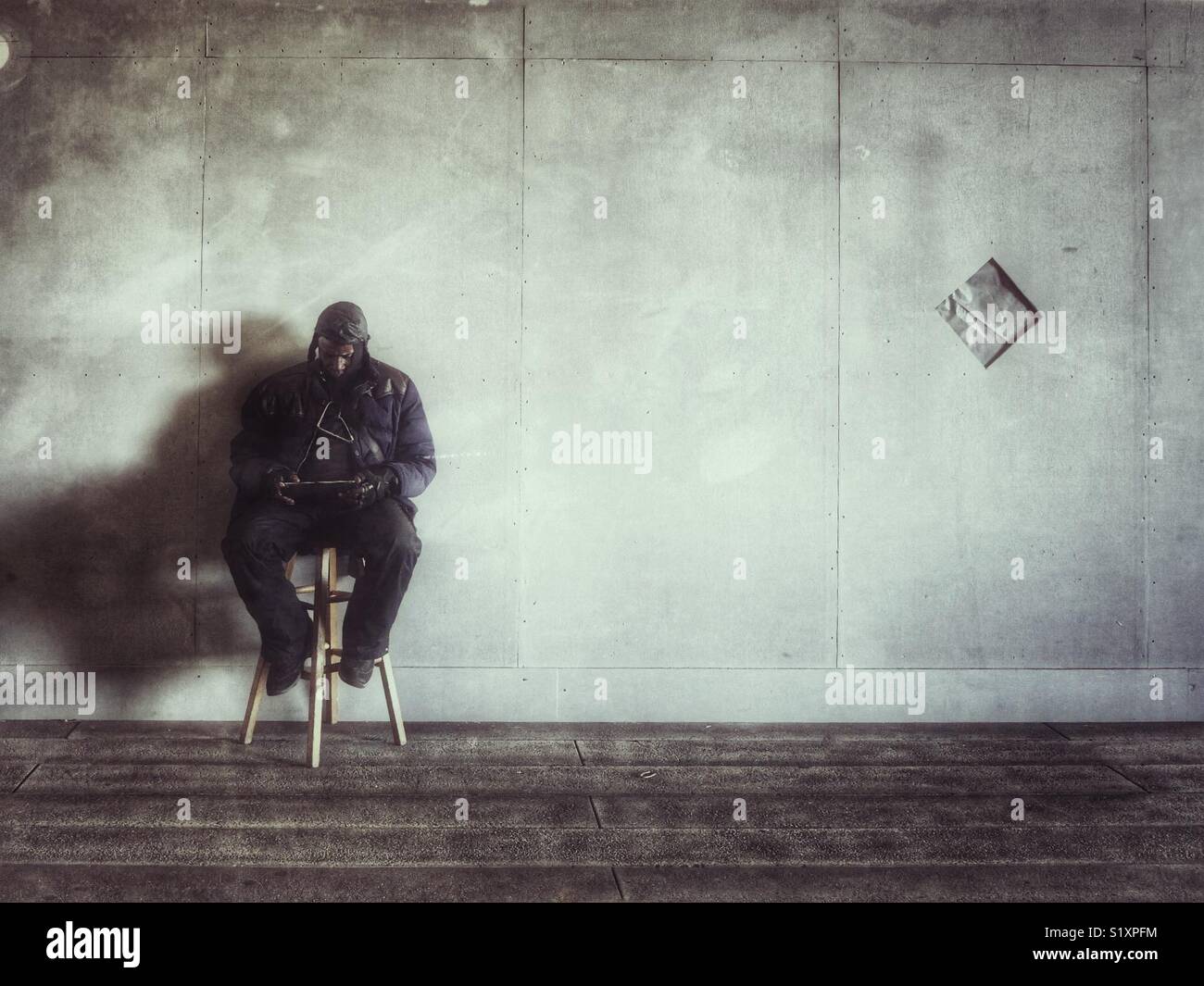 Mann saß auf einem Hocker in New York City seinen Tablet lesen. Stockfoto