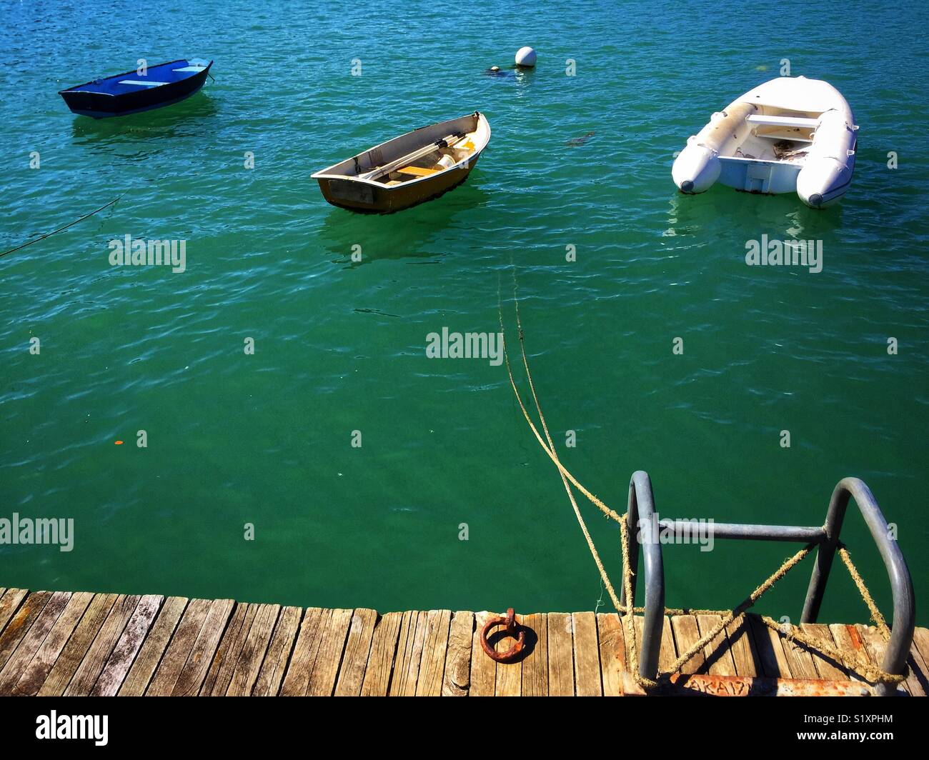 Drei Boote zu einem hölzernen Dock - Smartphone-aufgenommenes Stockfoto
