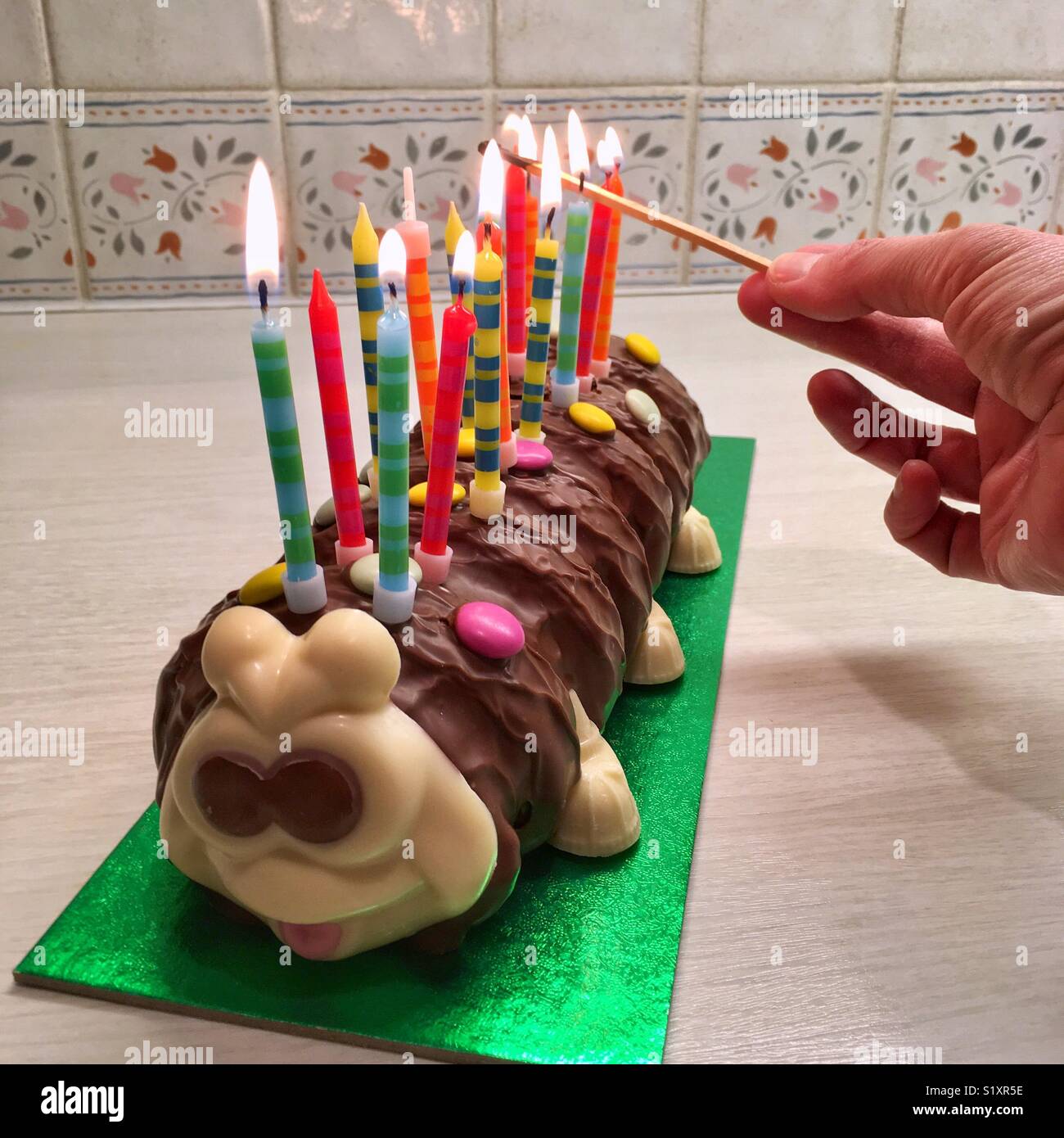 Anzünden von Kerzen auf einem Geburtstagskuchen Stockfoto