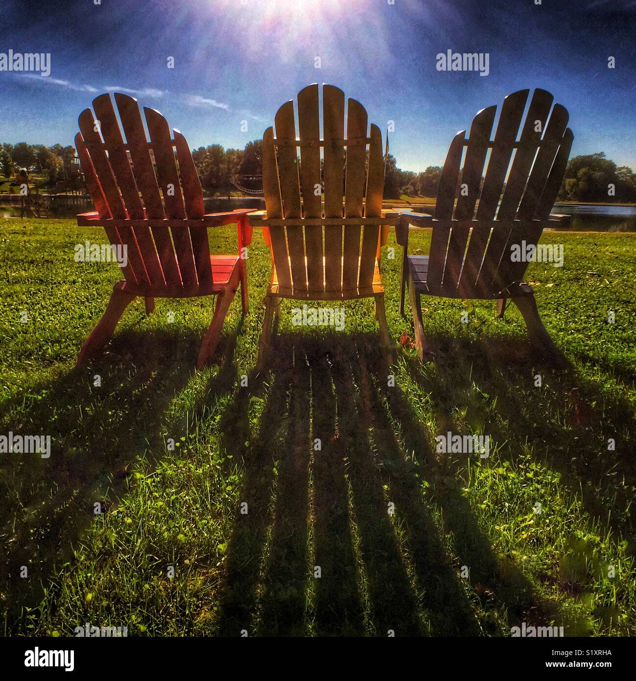 Adirondack Stühle auf dem See bei Sonnenuntergang - Smartphone-aufgenommenes Stockfoto