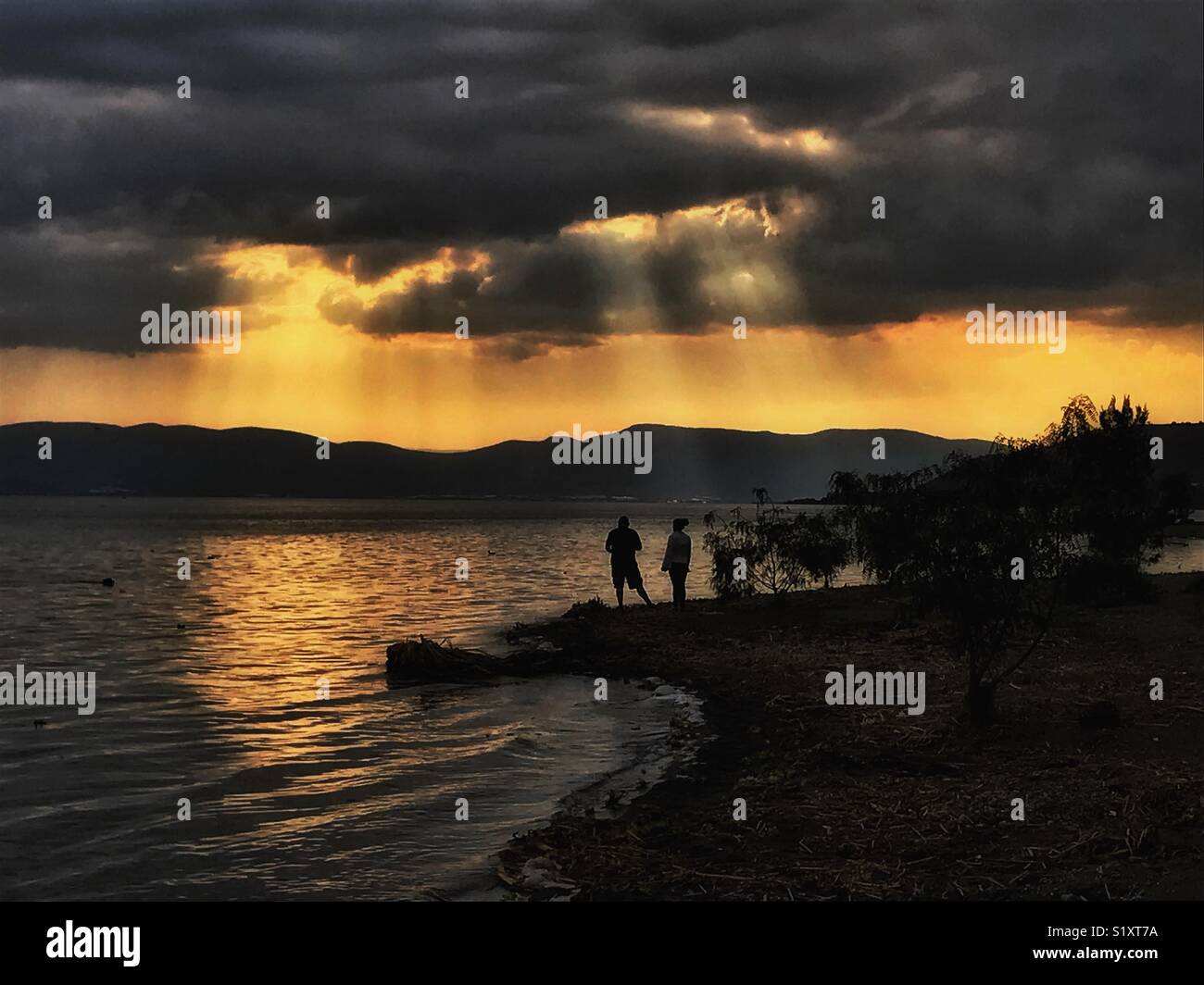 Abend Sonnenstrahlen leuchten Chapala See. Stockfoto