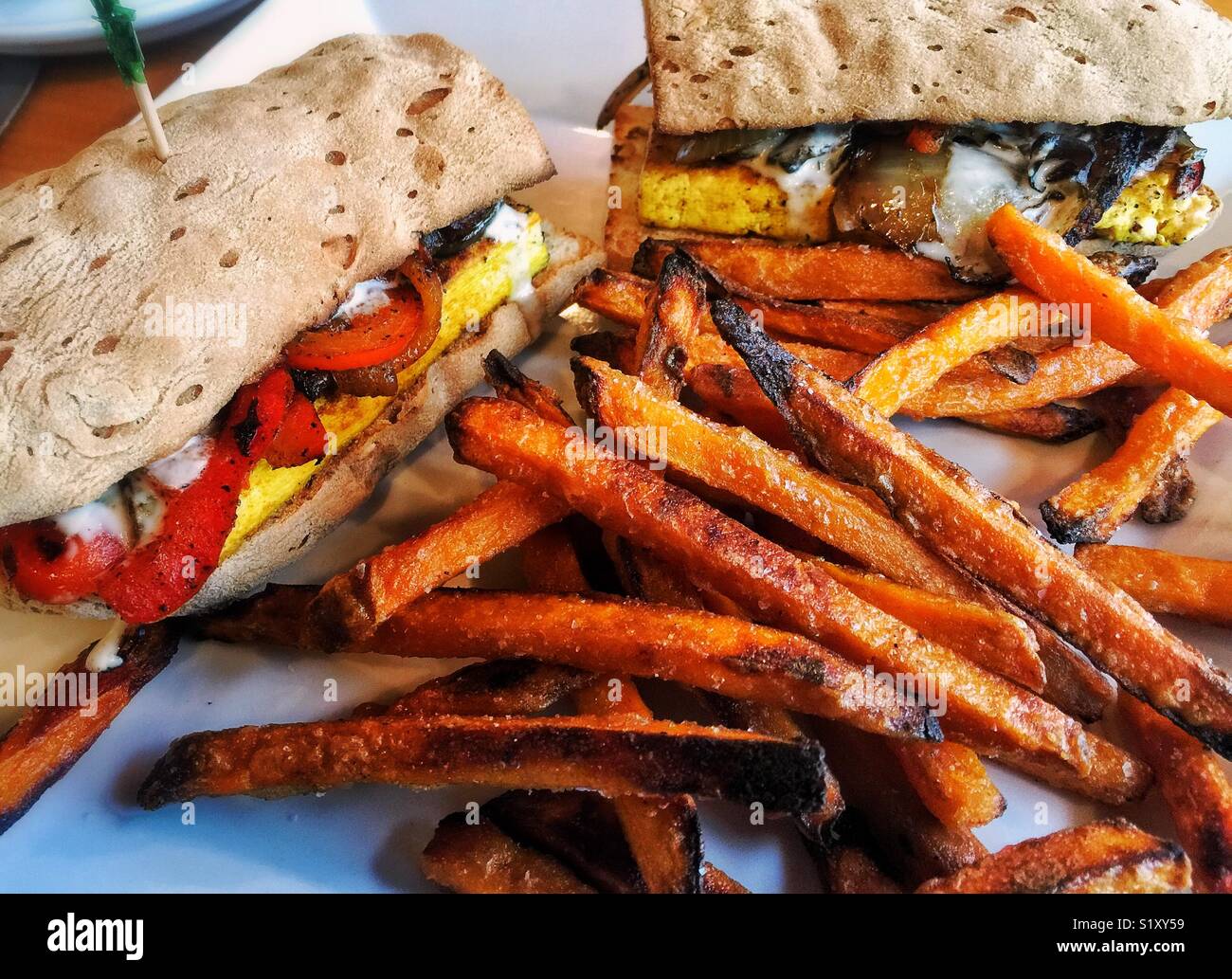 Süßkartoffel frites und vegan tofu Sandwich serviert in veganes Restaurant Stockfoto