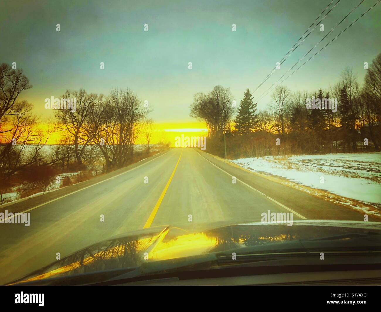 Straße im ländlichen Ontario, Kanada bei Sonnenuntergang von der Sicht des Fahrers Stockfoto